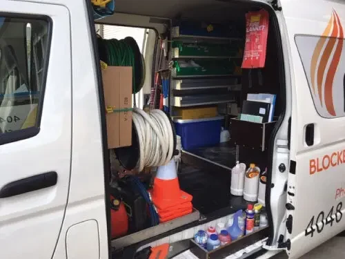 A Plumbers Express service van with its door open, showing the tools carried on board